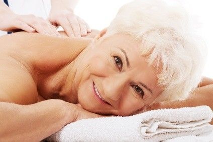 Une dame souriante entrain de se faire masser