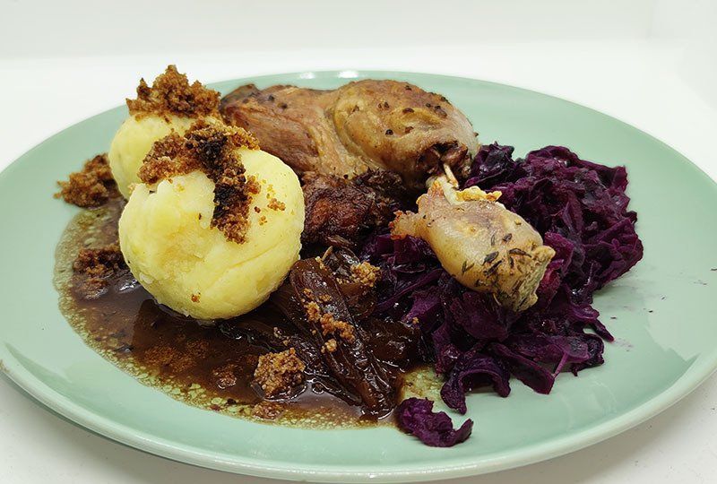 Entenkeulen mit Rotweinschalotten, Apfel-Blaukraut, Knödel und Butterbrösel