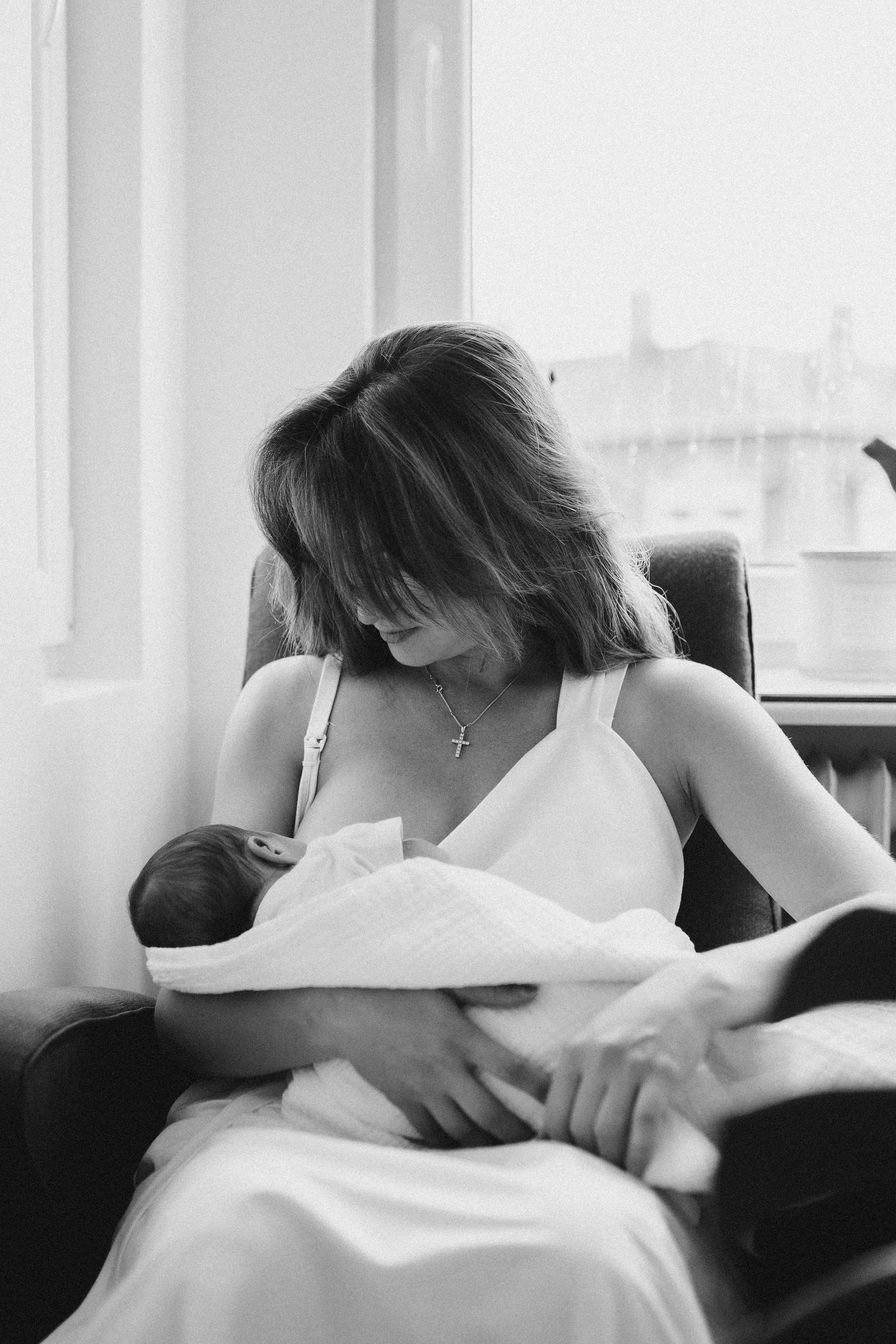 newbornshooting als homestory baby mit mama beim stillen