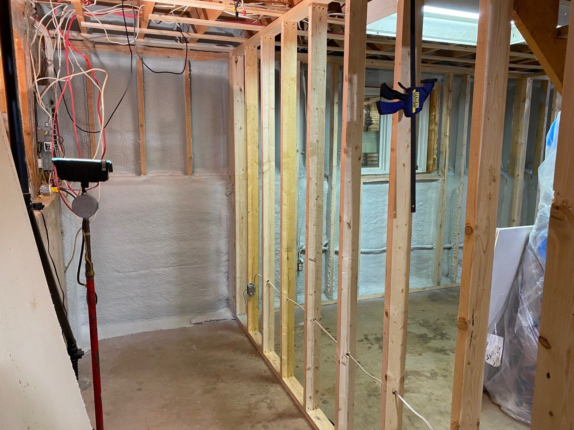 Insulator applying spray foam to roof truss