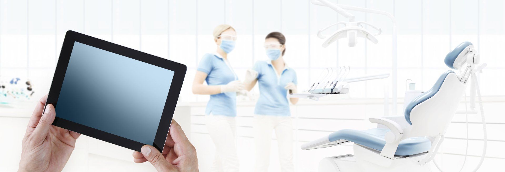 Touchscreen-Monitor mit Zahnarztpraxis-Mitarbeiterinnen im Hintergrund