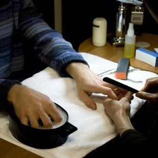 man's hands being pampered with nail care treatments