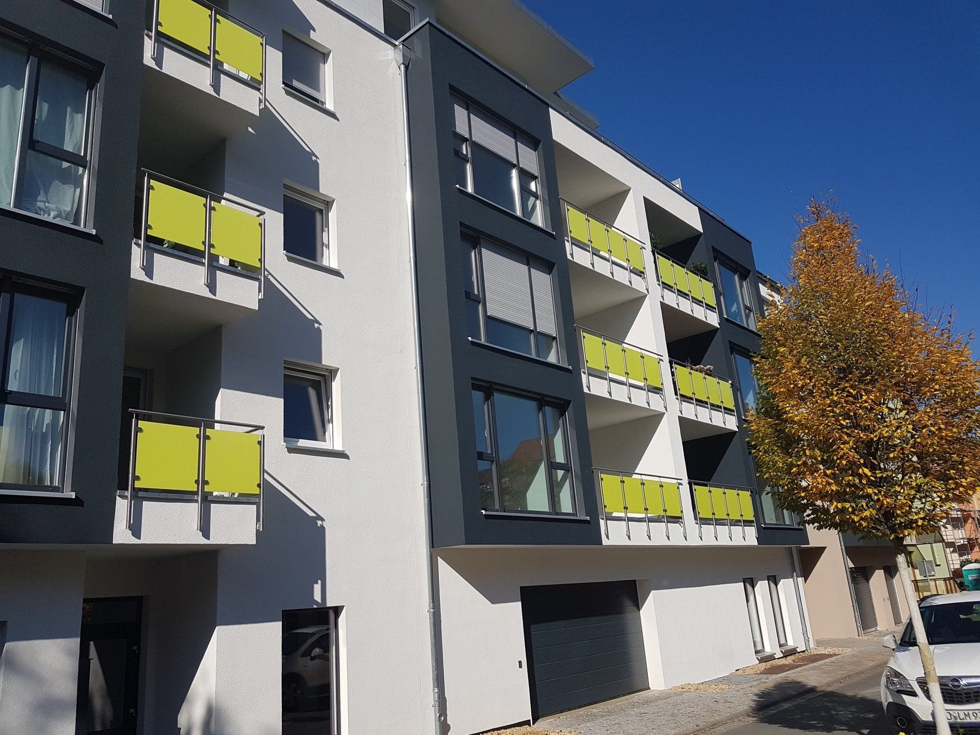 Modernes Mehrfamilienhaus mit Balkonanlage und Baum in Jena