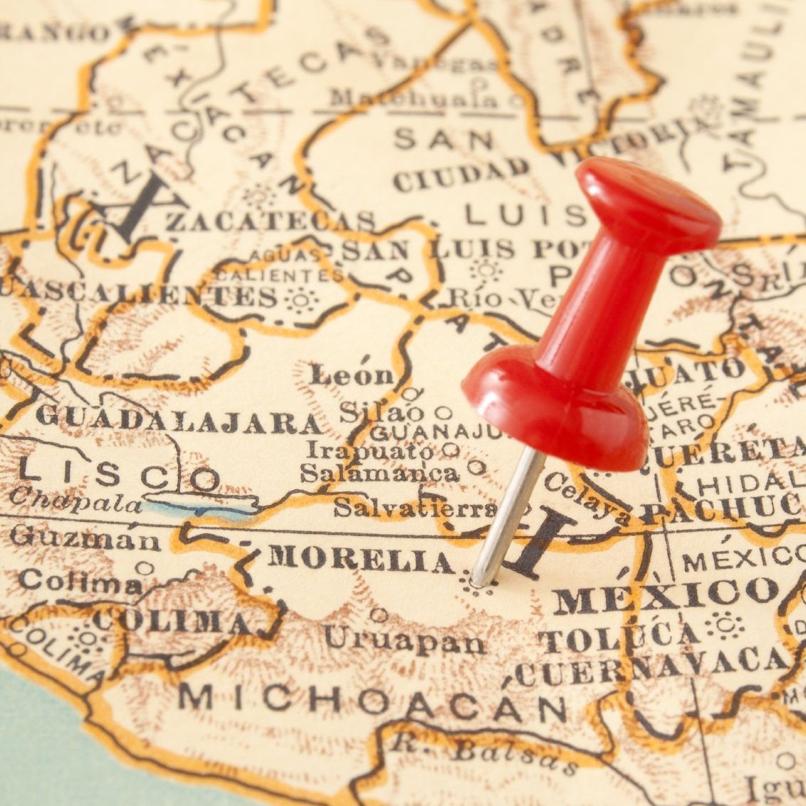 Kleiner Ausschnitt einer Weltkarte mit roter Nadel.