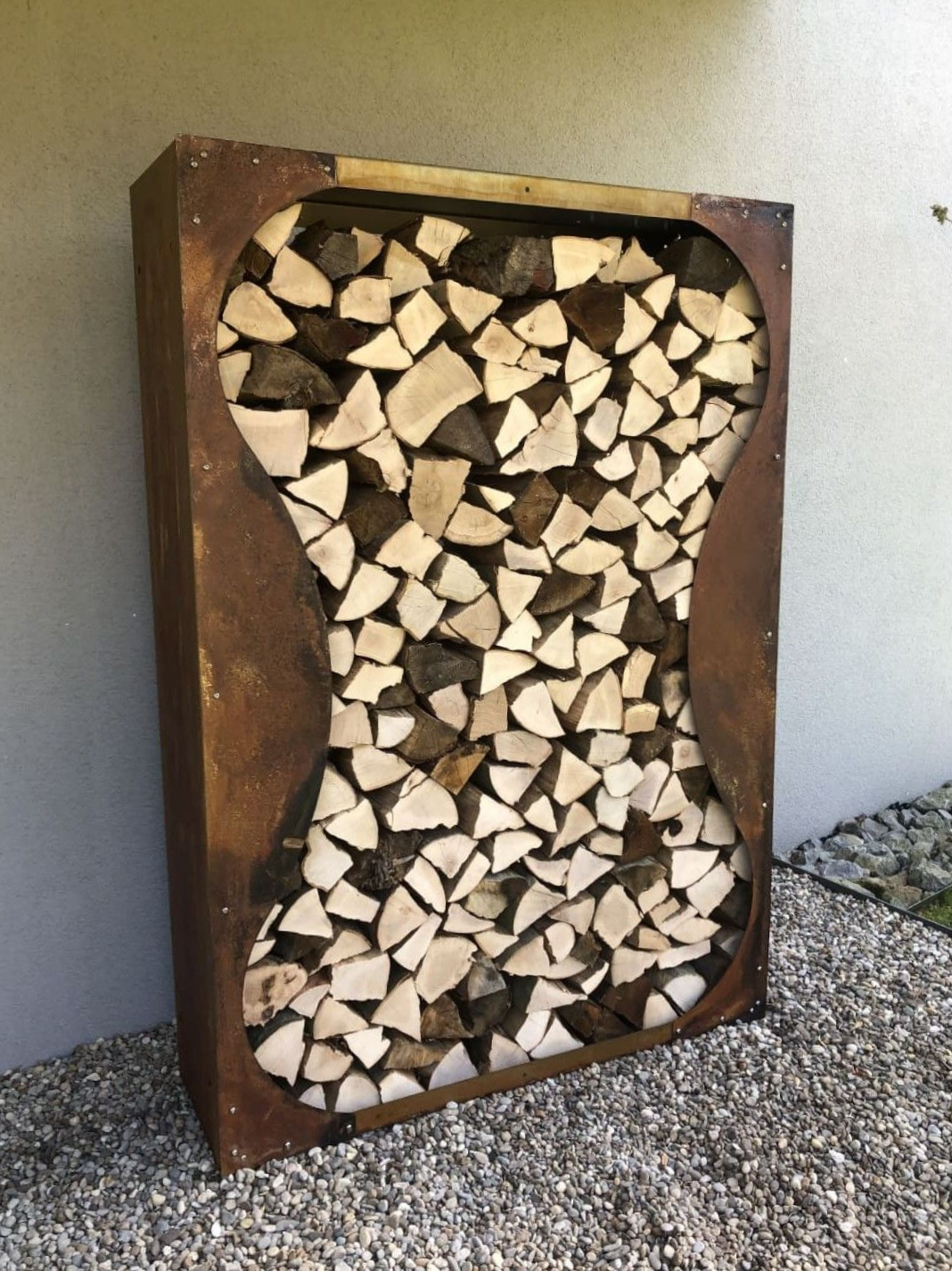 Kaminholzregal aus Cortenstahl mit Sanduhrdekor