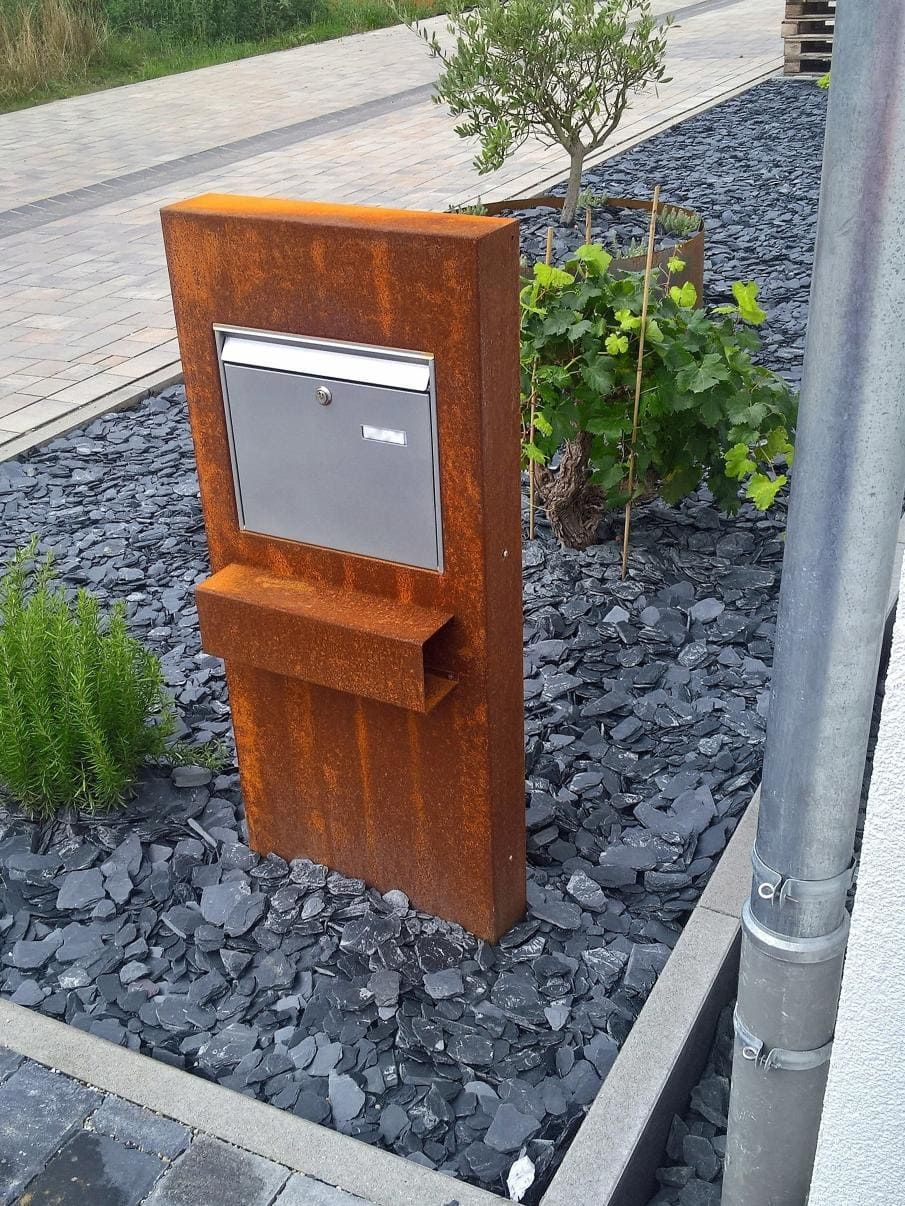 Cortenstahl Briefkasten Anlage mit Edelstahl Briefkasten und Zeitungsrolle steht in Stein Vorgarten