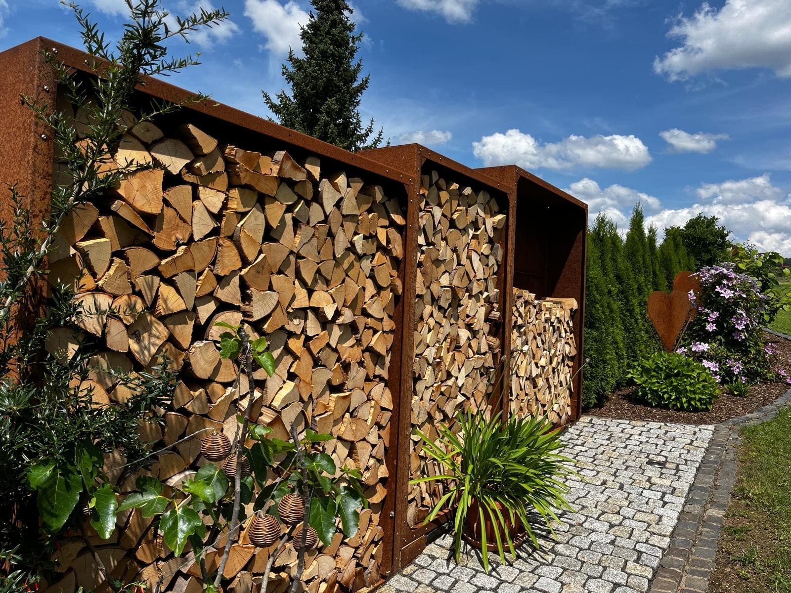 Kaminholzregale aus Cortenstahl als Sichtschutz im Garten