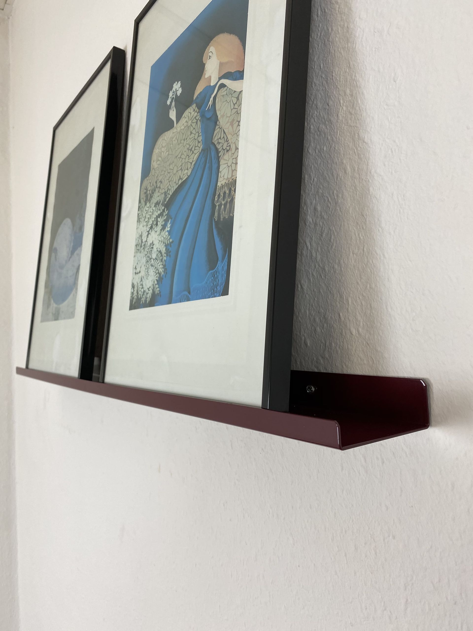 Wandregal aus Metall hält zwei große Bilder