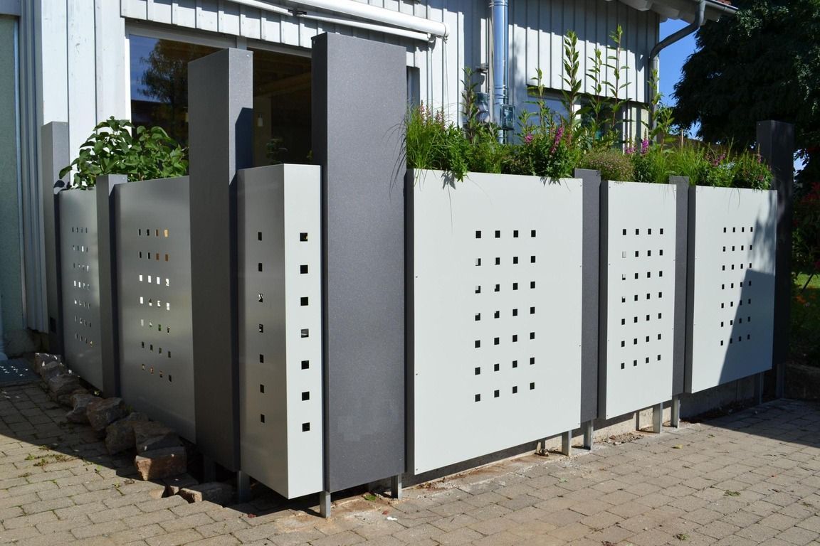 Sichtschutz mit Stelen aus Metall und begrünten Pflanzkübeln in hellgrau und dunkelgrau beschichtet