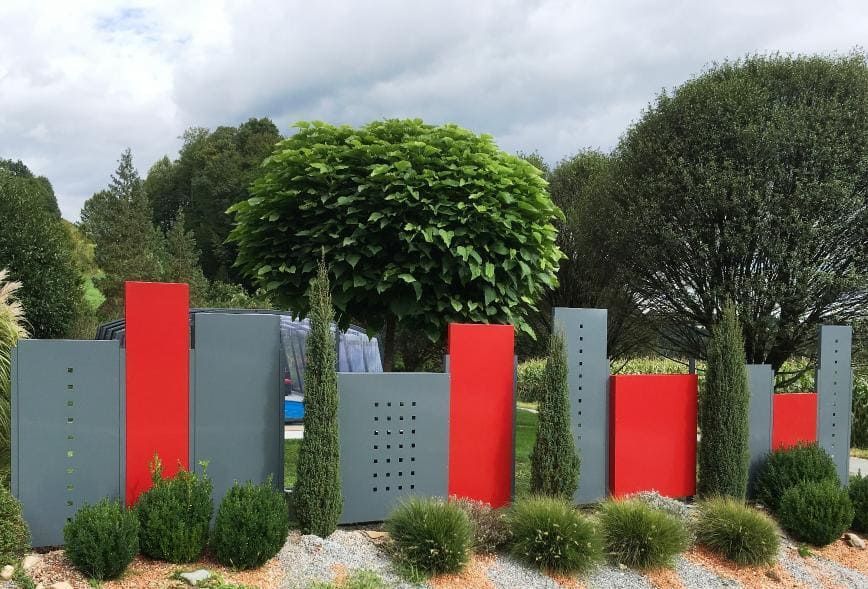 Zaunsystem aus Metall in knalligen Farben beschichtet, steht im Garten