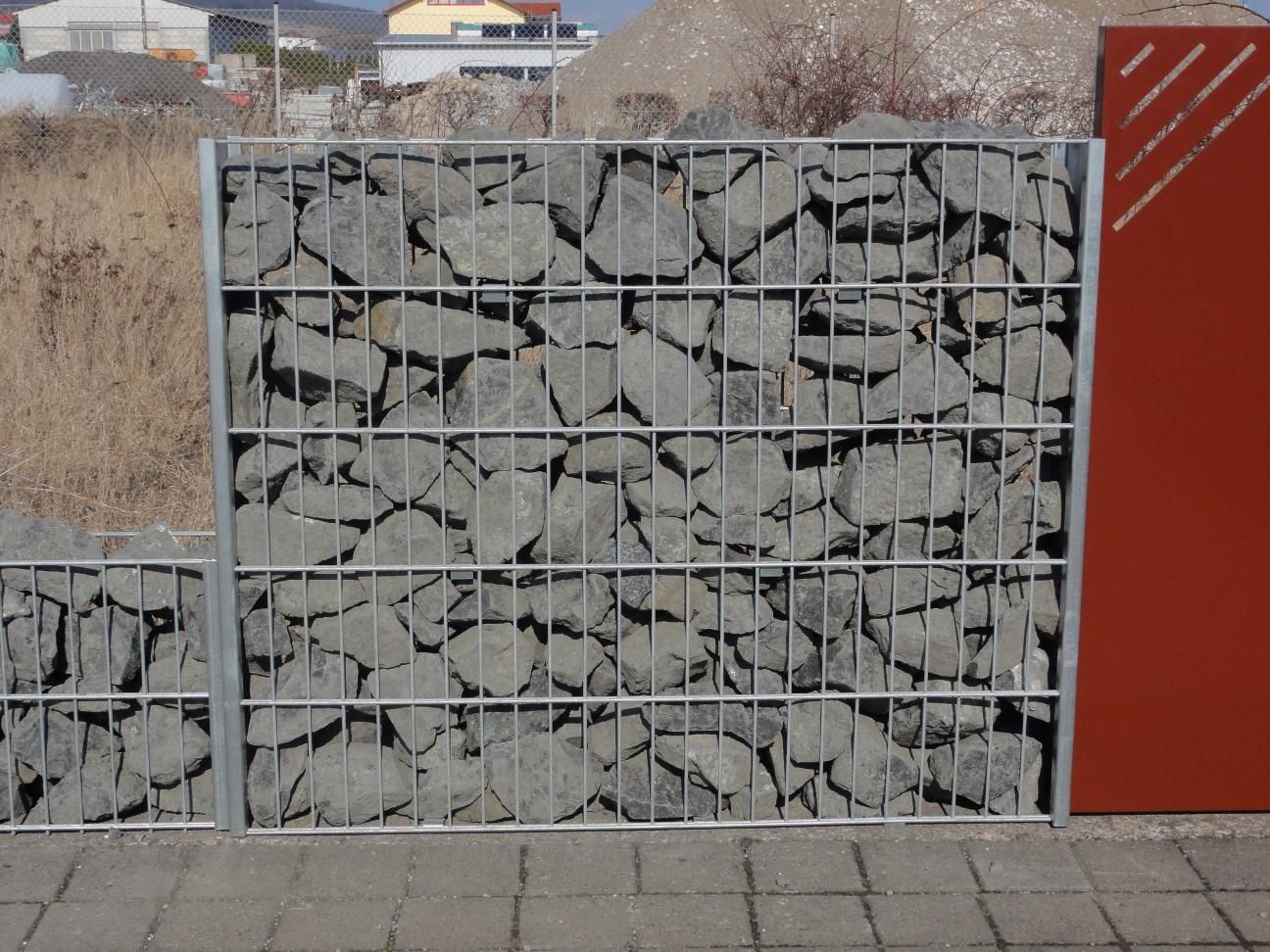 Gabionen Steinkorb gefüllt mit grauen Steinen als Sichtschutz im Garten