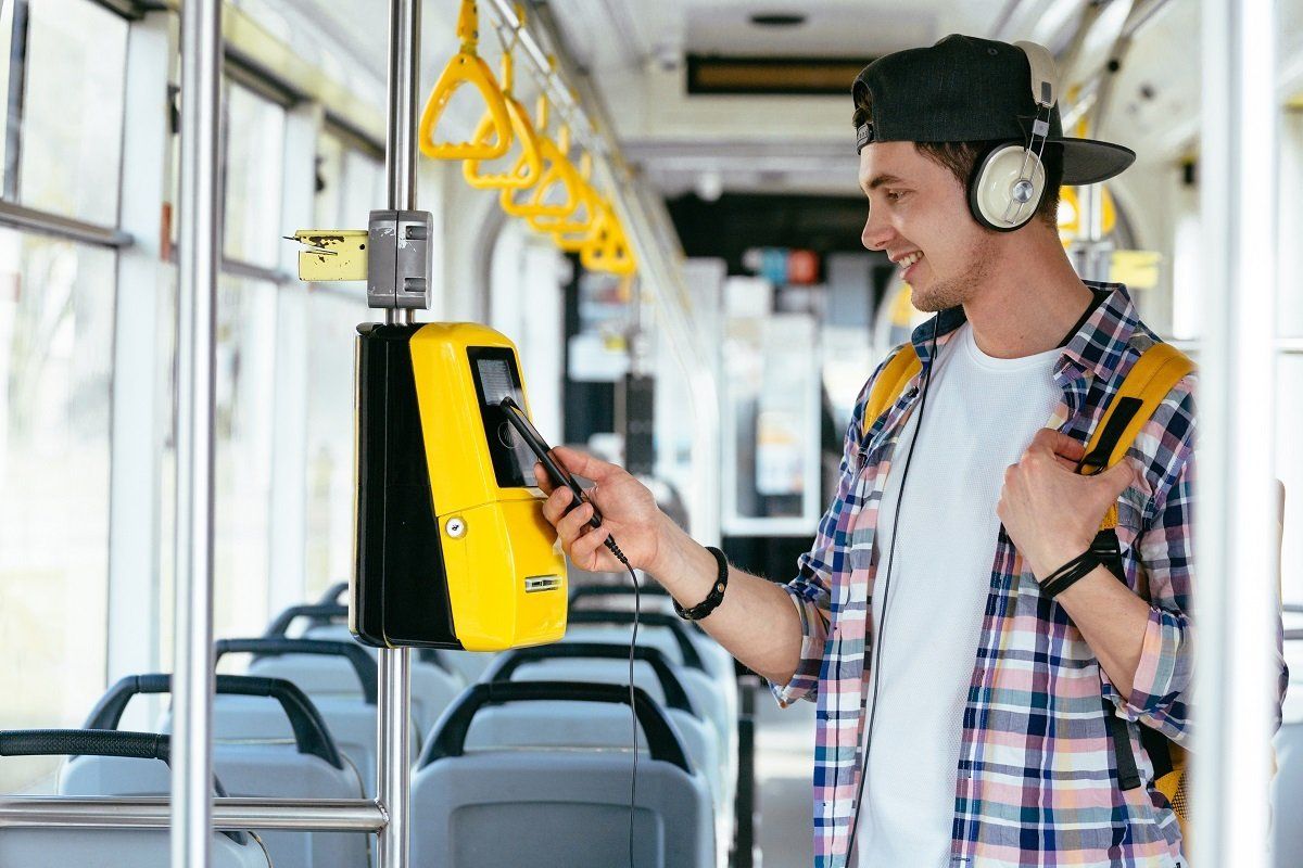 Ein Jugendlicher kauft im Bus eine Fahrkarte mit seinem Smartphone. Ein Jugendlicher kauft im Bus eine Fahrkarte mit seinem Smartphone.