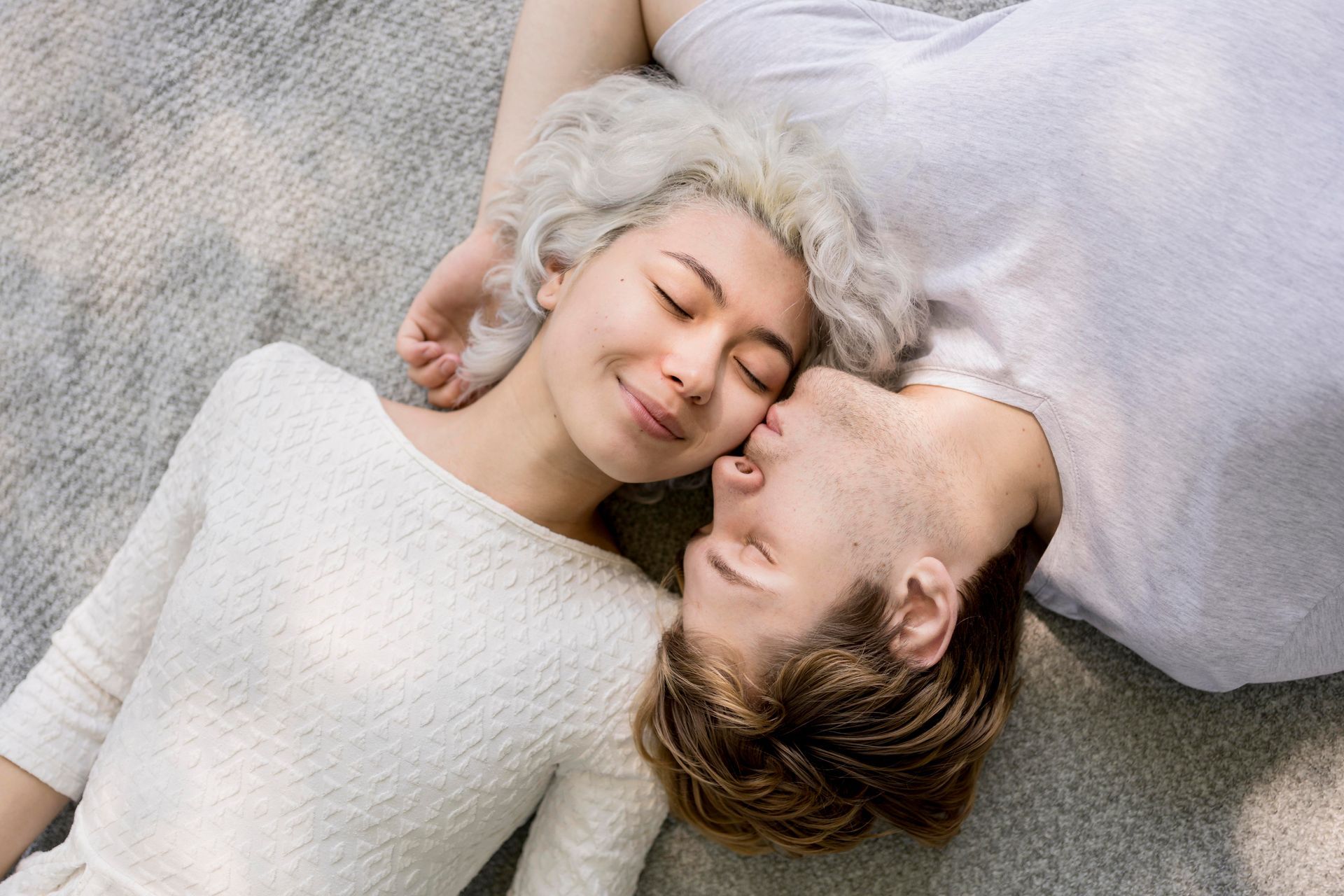 Achtsames Paar liegt entspannt nebeneinander, Augen geschlossen – Nähe, Verbundenheit und mitfühlend