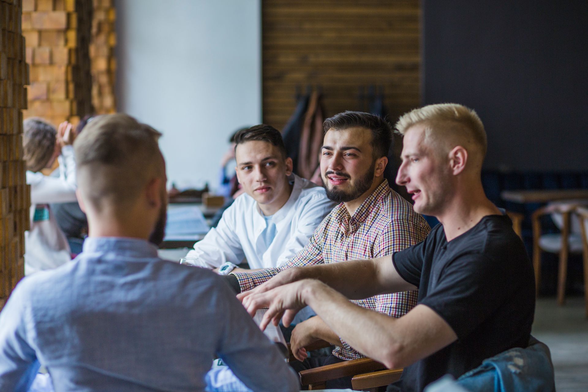 junger-mann-der-im-restaurant-erklart-strategie-zu-seinen-freunden-sitzt