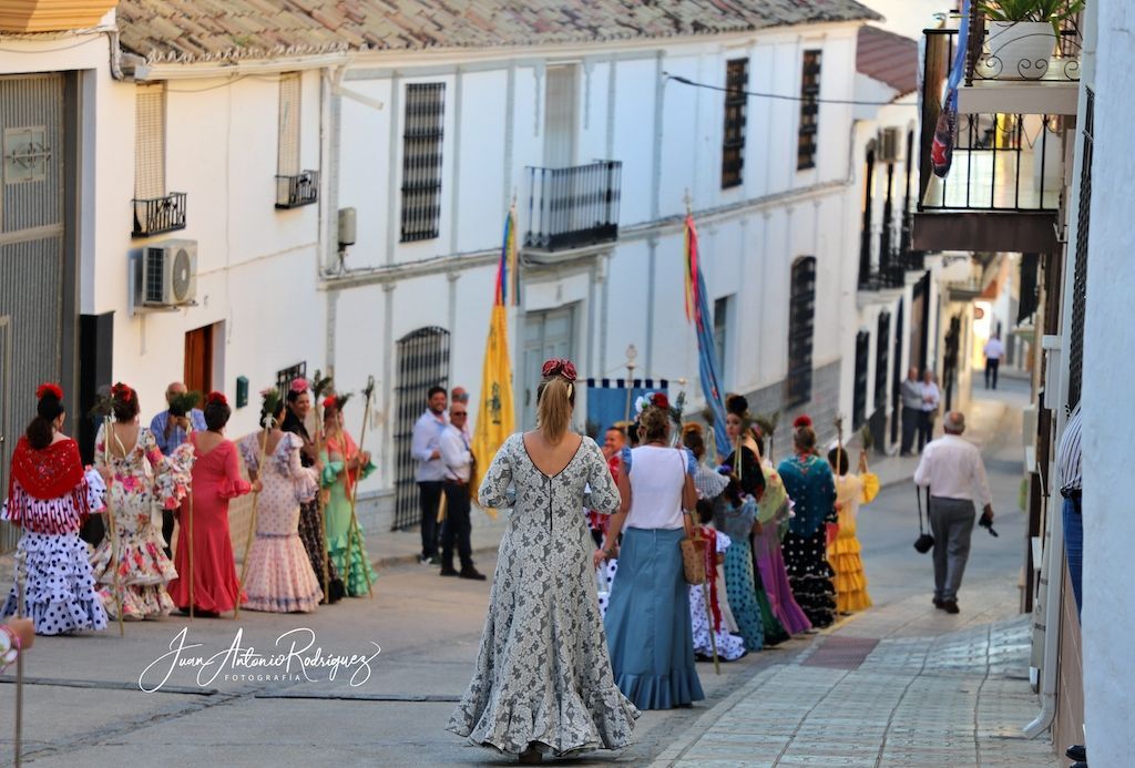 mujeres de flamenca desfilan en la procesion de Valenzuela