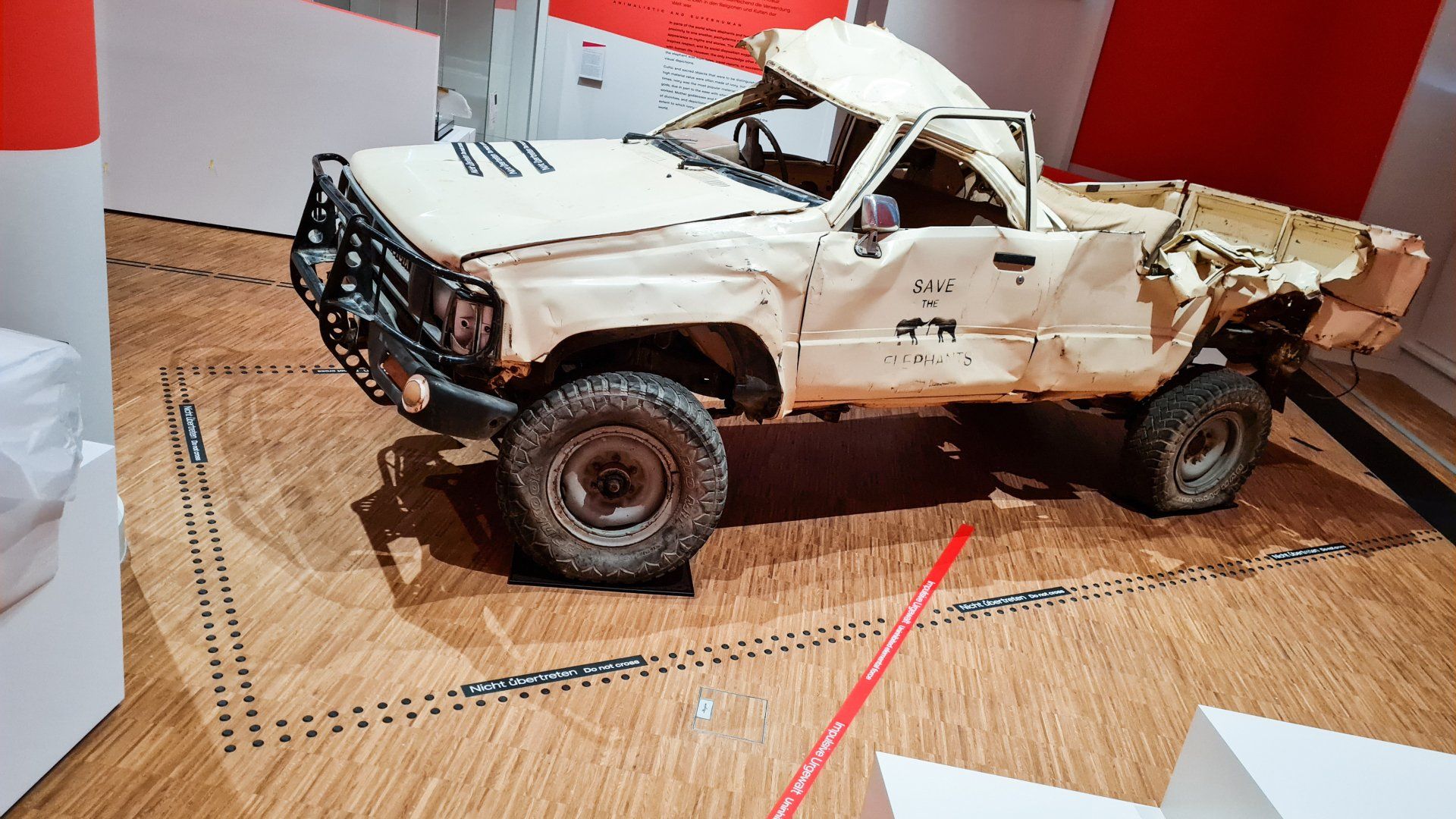 Ein demolierter Truck mit vielen Dellen und verschobener Karosserie. Darum herum führt ein Bodenleitsystem