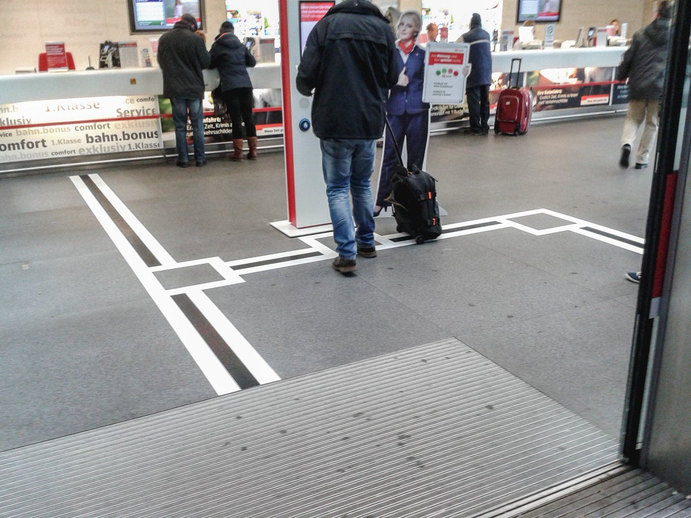 Ein Bodenleitsystem bei der Bahn. Es leitet von der Eingangstür zum Serviceterminal und zu den Schaltern