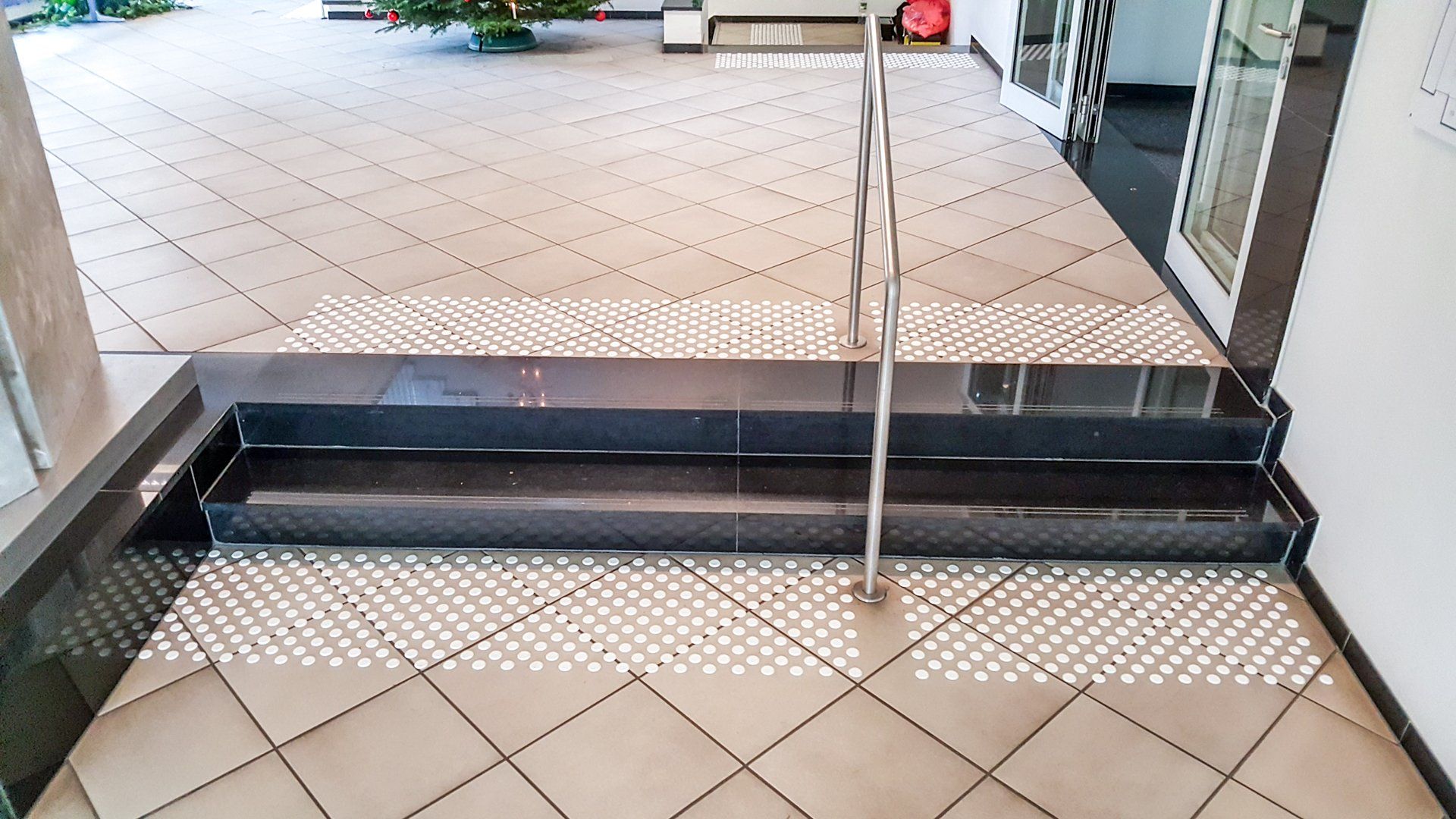 Zwei Treppenstufen mit Geländer und Stufenmarkierungen