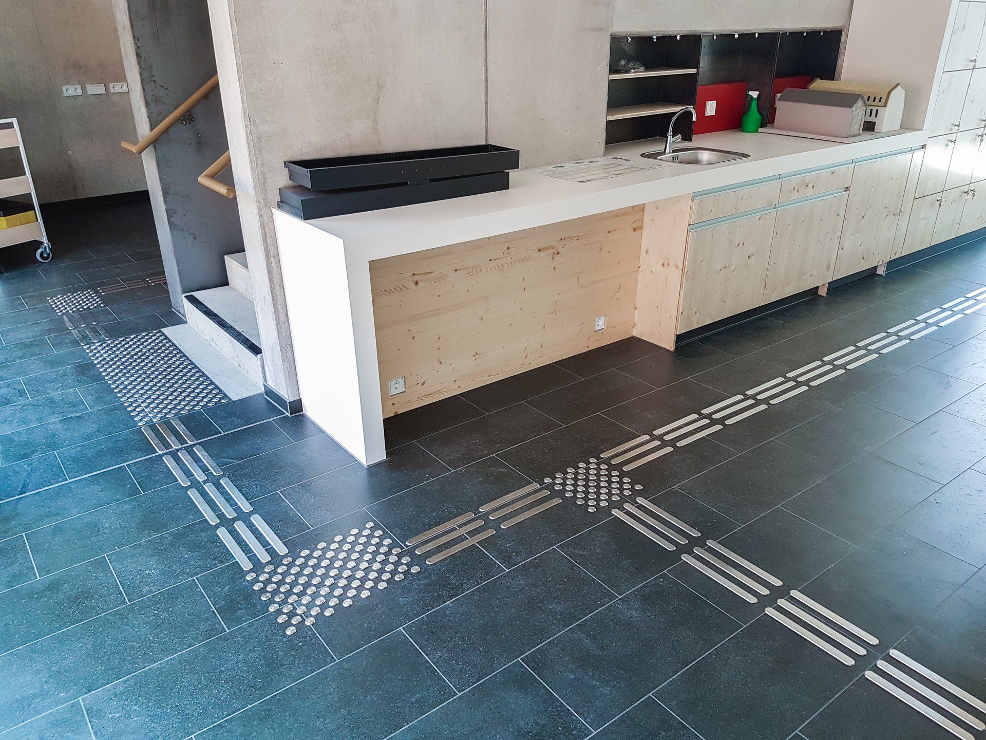 Bodenleitsystem, dass zu einer Kaffeeküche führt.