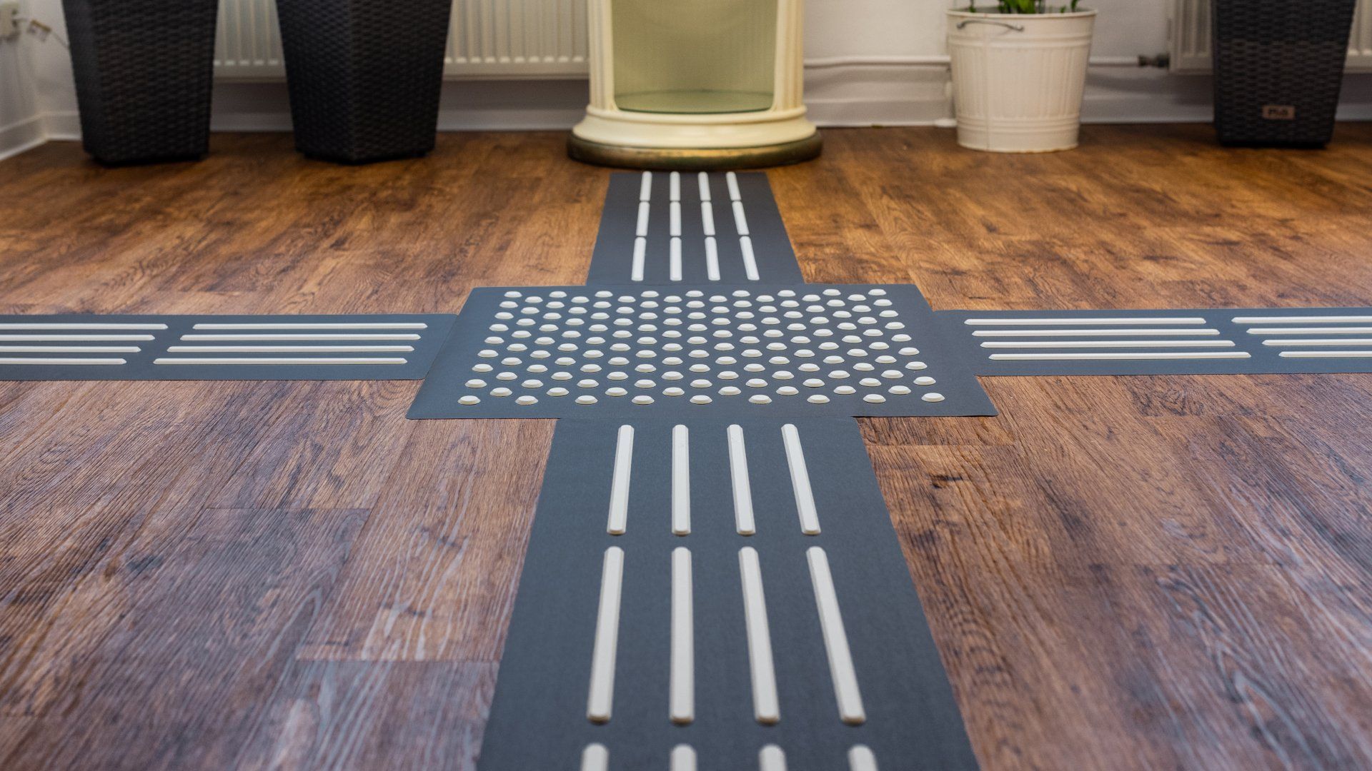 Das Bodenleitsystem TAKTILo führt von einer Kreuzung zu einem Ausstellungsstück. Der hohe visuelle Kontrast der Indikatoren zum Grundmaterial und zum Boden erleichtert die Sichtbarkeit des Leitsystems.