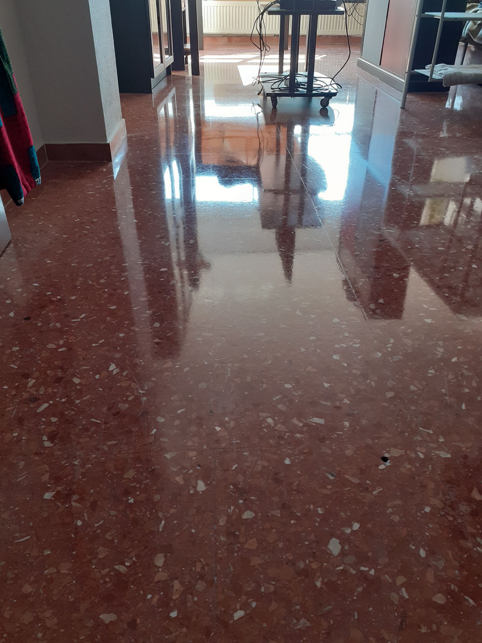 Suelo de terrazo recuperado en comedor tras pasar la pulidora.