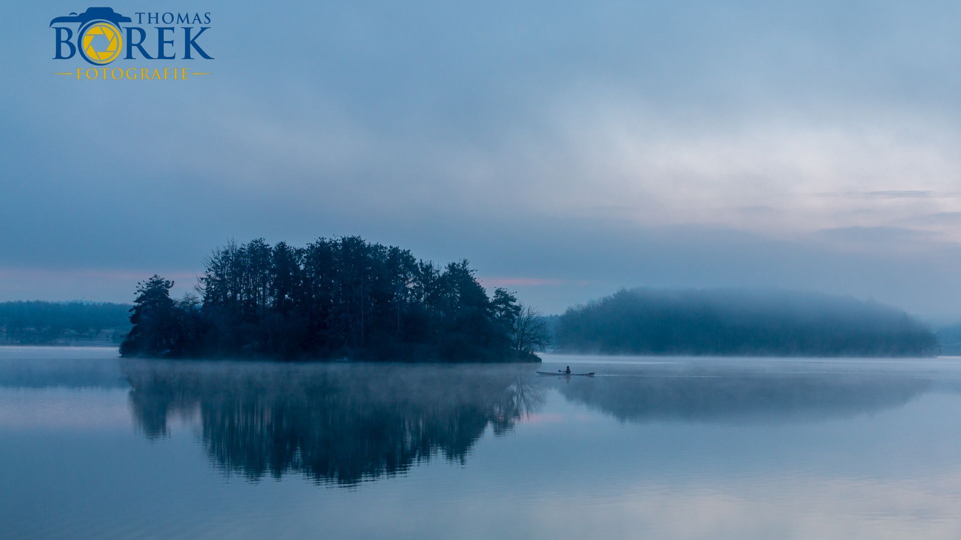 Sonnenaufgang im Winter, einzelner Bootsfahrer