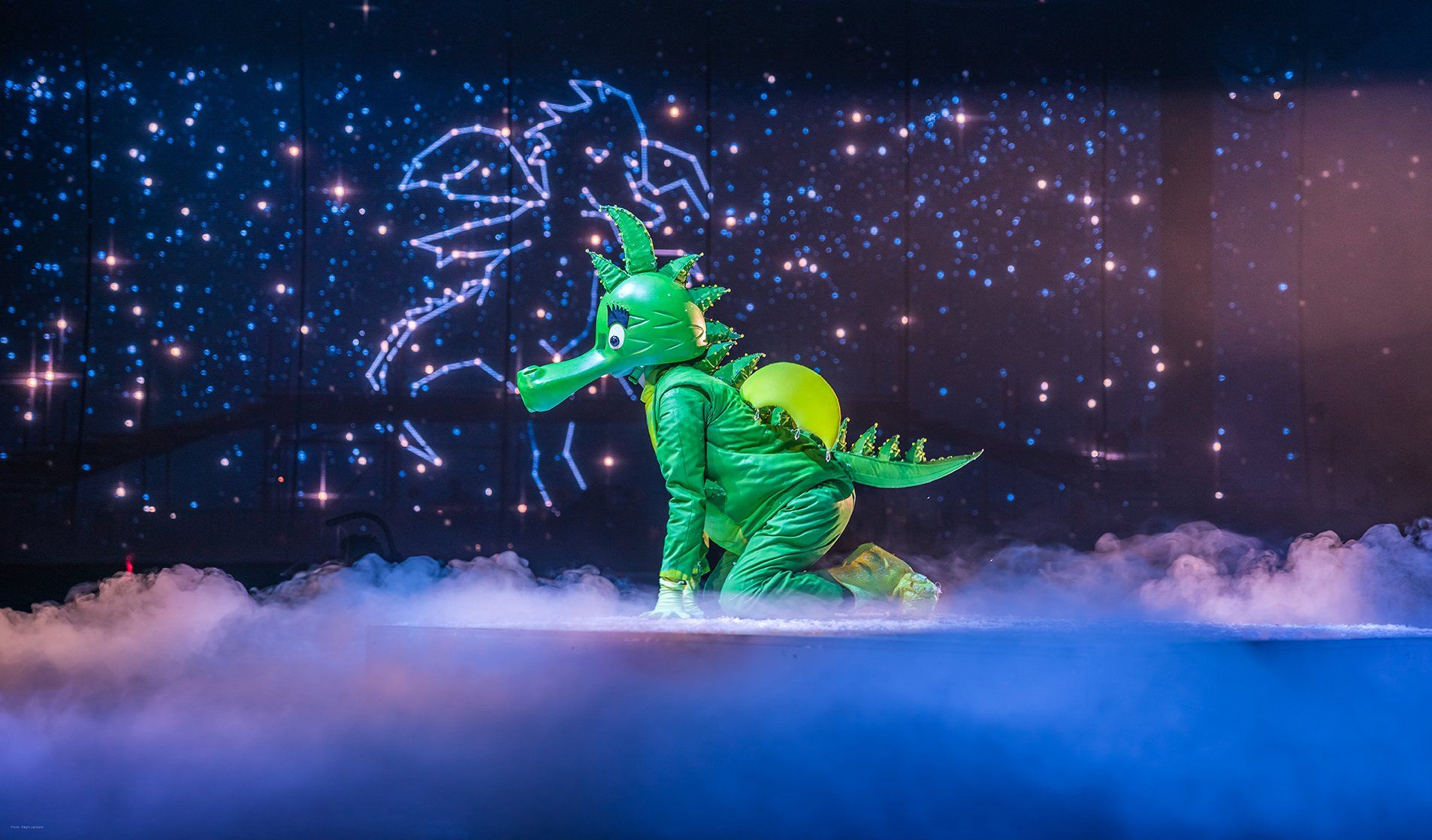 Der Drache Tabaluga kniet auf der Bühne