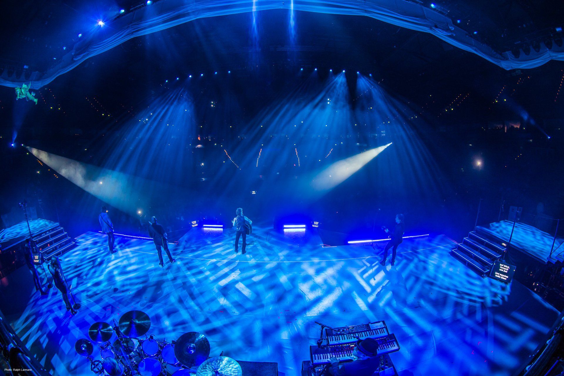 Peter Maffay mit Band singend auf der Bühne, Ansicht von hinten