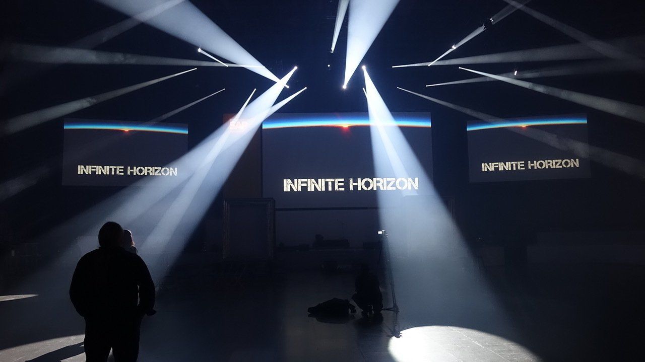 Effektvolle Beleuchtung der Bühne mit Schriftzug: Infinite Horizont