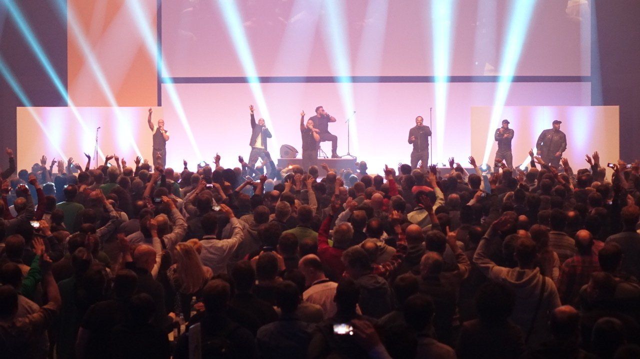 Jubelnde Menschen vor einer Bühne mit Musikern