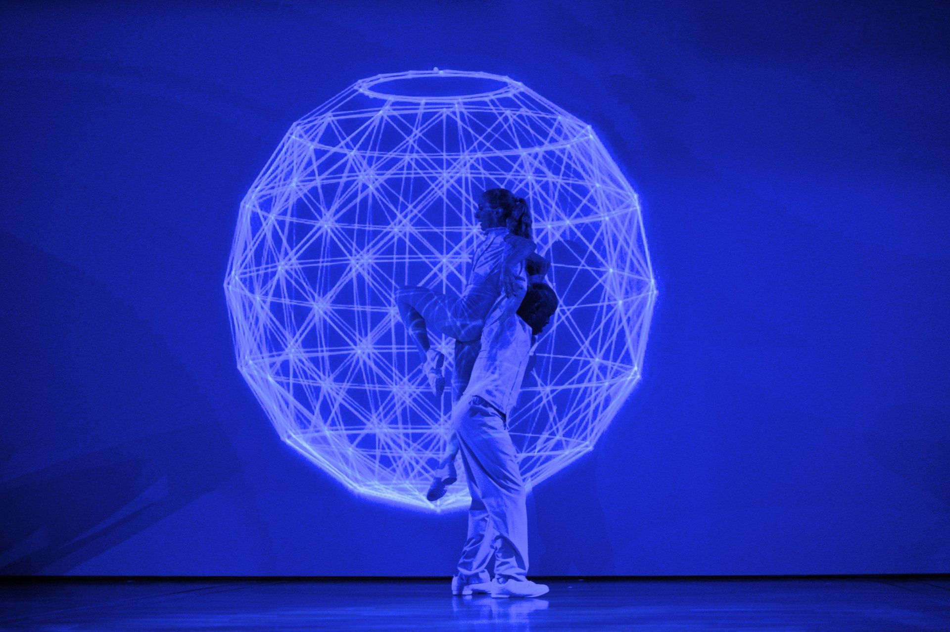 Zwei Tänzer vor einer Weltkugel