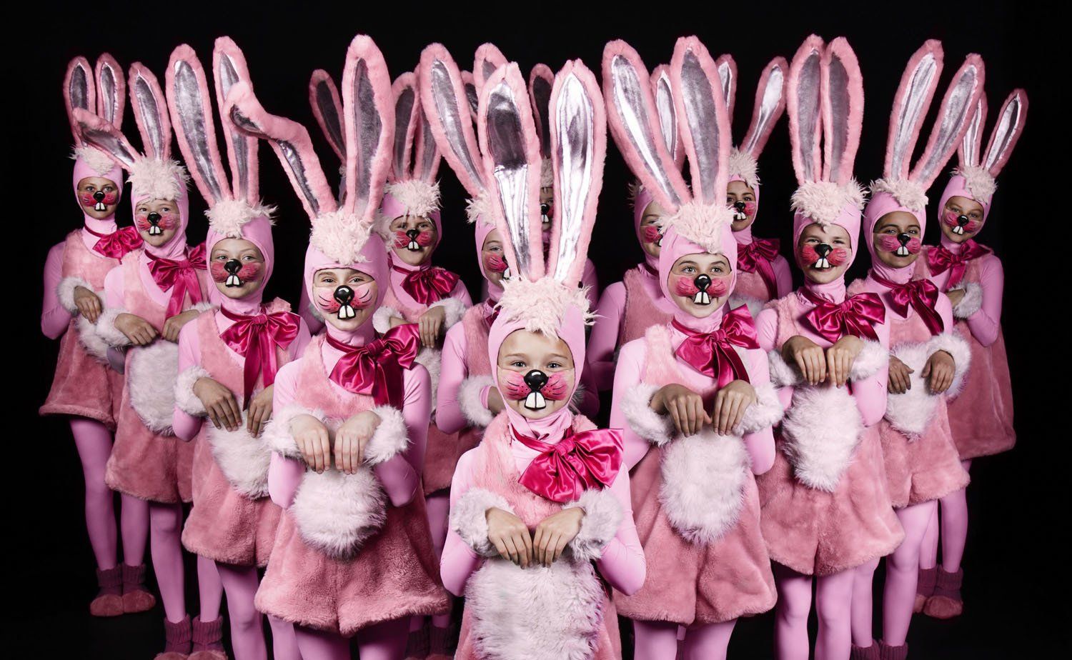 Viele Kinder in rosa Hasenkostümen