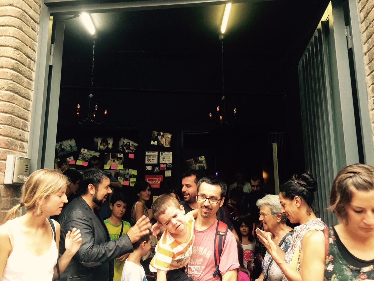 Padres y niños saliendo del teatro y saludando al mago Eugenio