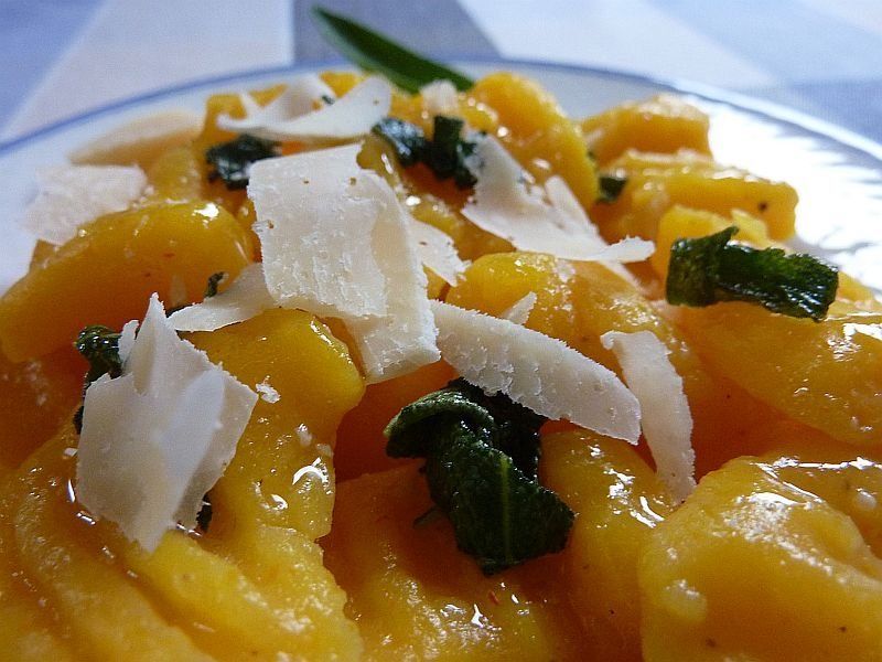 orangefarbene Klöschen mit Käse bestreut