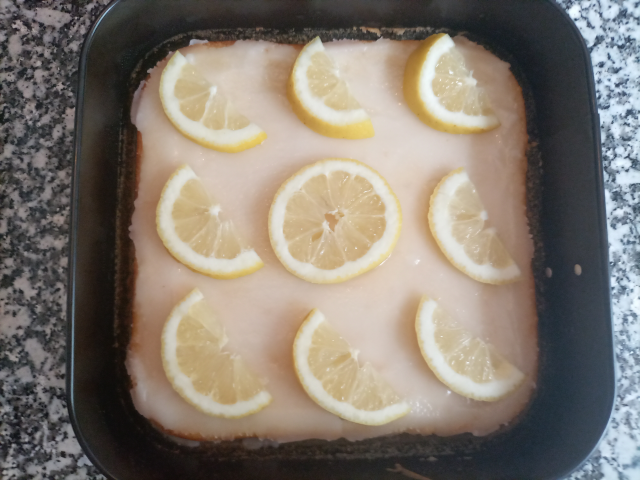 Kuchen im Blech belegt mit Zitronen
