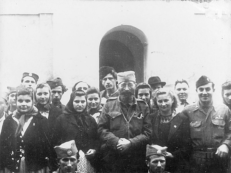 Le général Draja Mihaïlovic entouré de civils serbes devant l'église orthodoxe de Pragnani le 6 septembre 1944 et le capitaine Michael Rayachic de l'OSS.