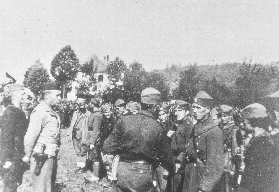 Le général Draja Mihaïlovic (de dos) et le colonel Robert McDowell (de profil veste claire) passant en revue les Tchetniks de Bosnie occidentale sur la Trebava en octobre 1944.