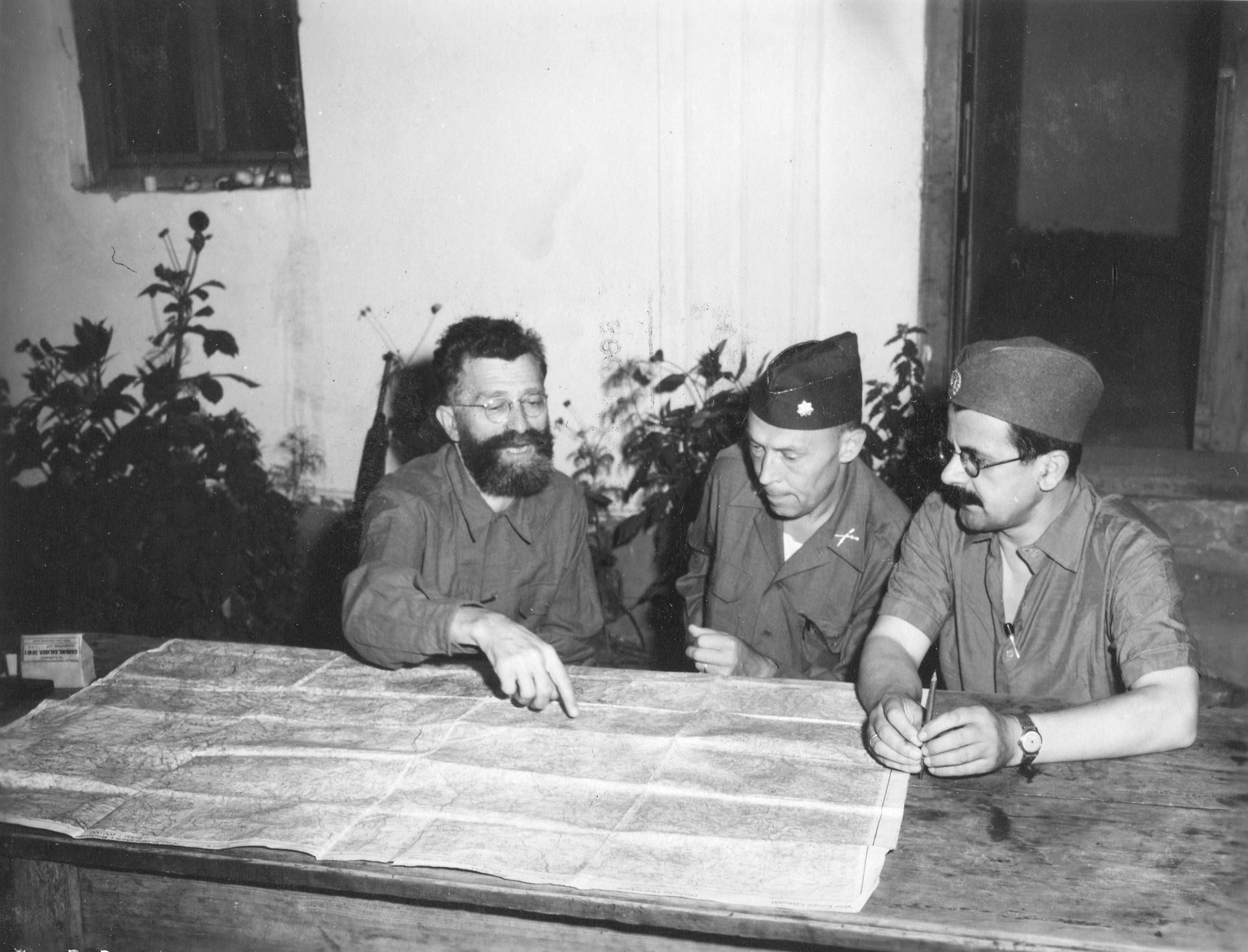 Le général Draja Mihaïlovic et le Colonel (OSS) Robert McDowell étudient la situation présente sur une carte d’état-major le 30 août 1944 à Pragnani en Serbie. (NARA.)