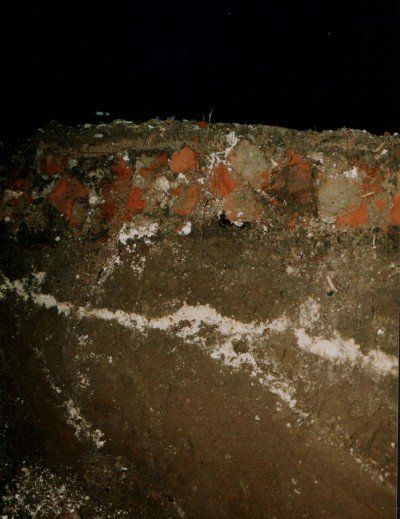 Le sol de l'Eglise (couche blanche) sous une cinquantaine de centimètres de terre, puis, au dessus, les restes du sol de la mosquée