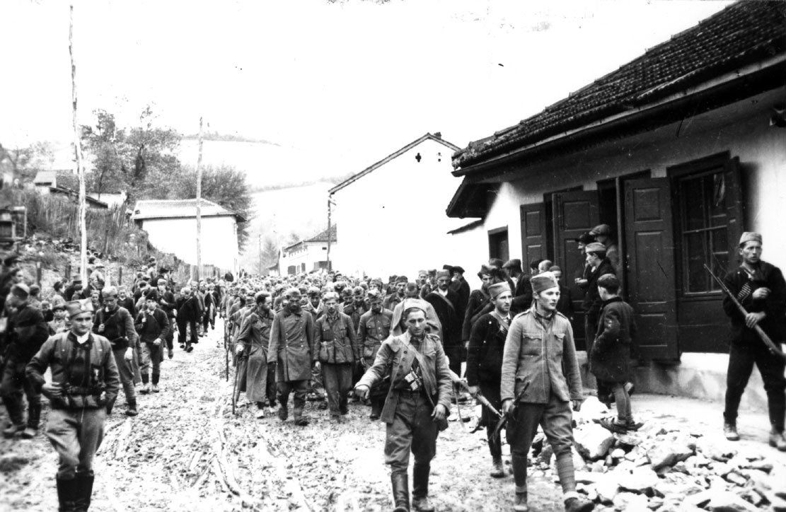 Les Tchetniks du général Mihaïlovic escortent par la rue d'un village les premiers prisonniers de guerre nazis en Europe occupée.