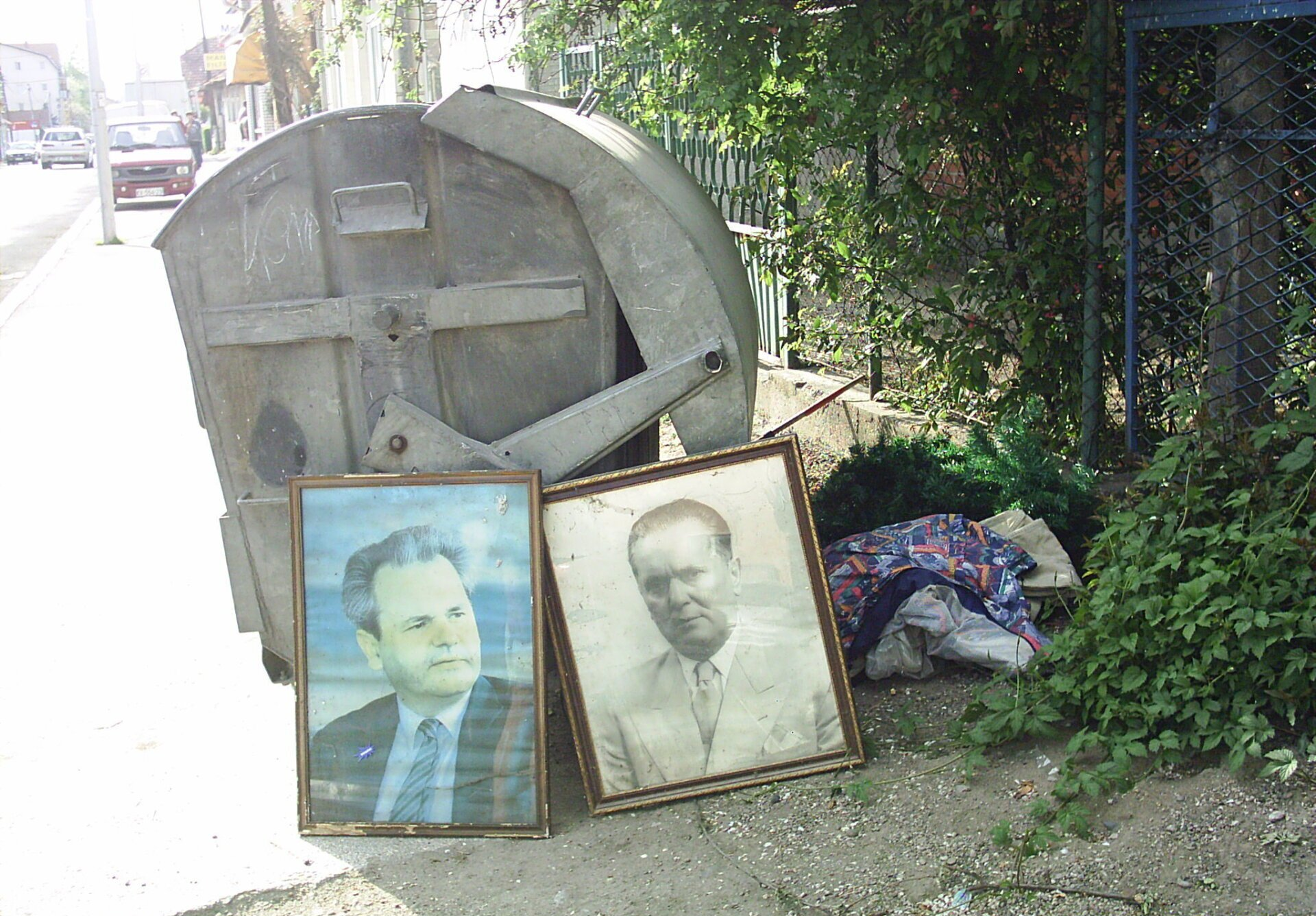 Conteneur urbain à ordures ménagères dans une rue en Serbie près duquel ont été abandonnés de vieux portraits de Tito et de Milosevic. Copyright www.pogledi.fr