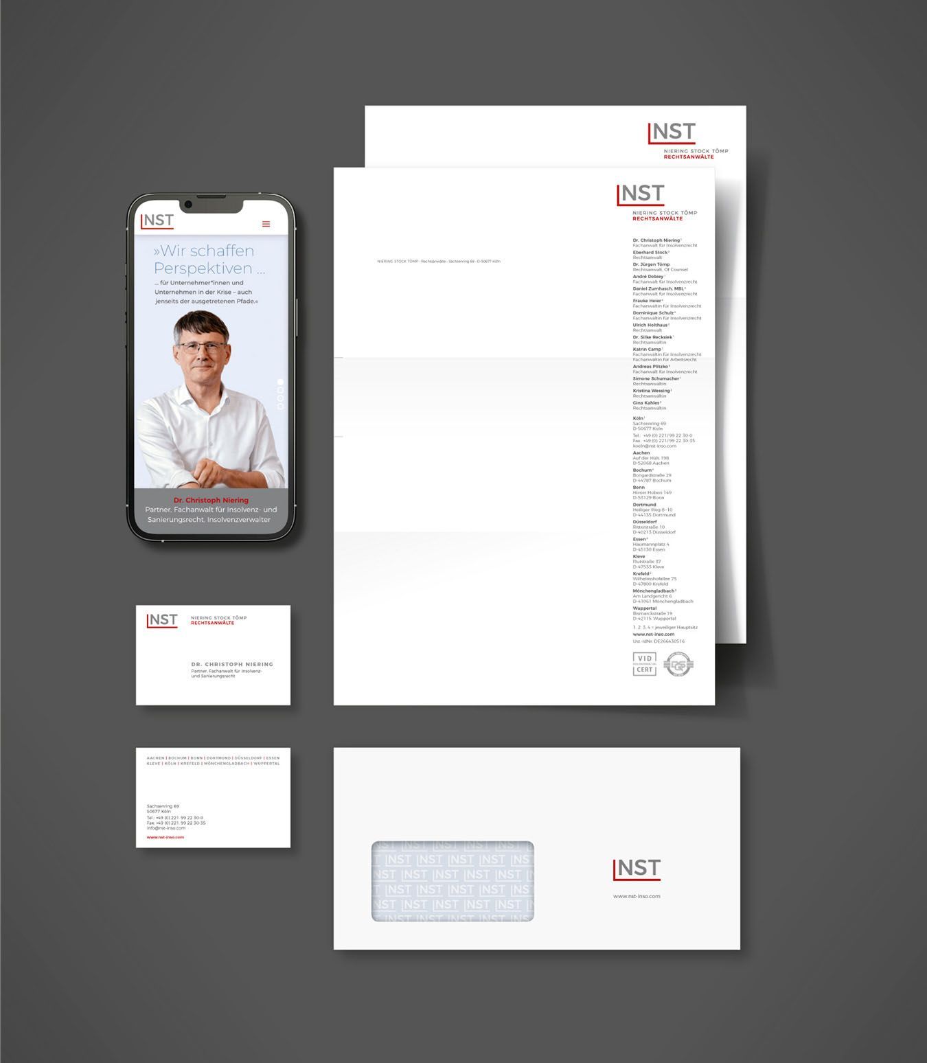 NST Geschäftsaussttaung NST Geschäftsausstattung mit Erste-und Zweiteseite Briefbogen sowie Visitenkarte, ein DIN lang-Umschlag, Smartphone, auf dem die Startseite der NST-Homepage zu sehen ist.