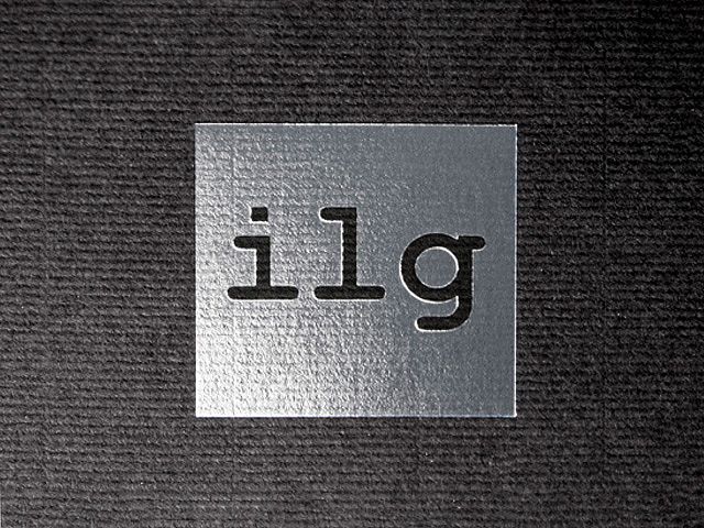 Silberfoliendruck Detailaufnahme, Silberfoliendruck des ilg Logos auf schwarzem Strukturpapier.