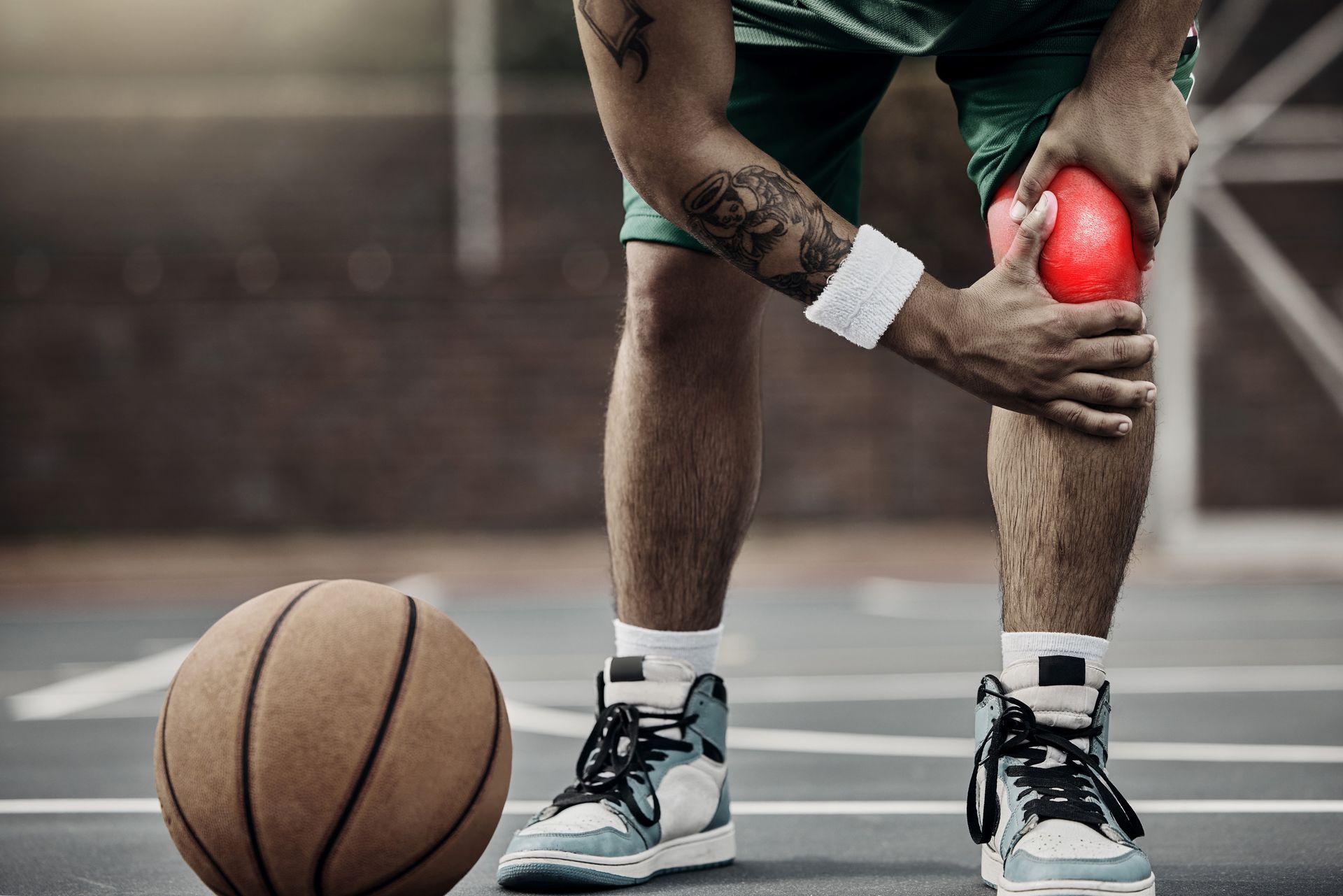 Ein Sportler mit Patellaspitzensyndrom hält sich das Knie vor Schmerzen