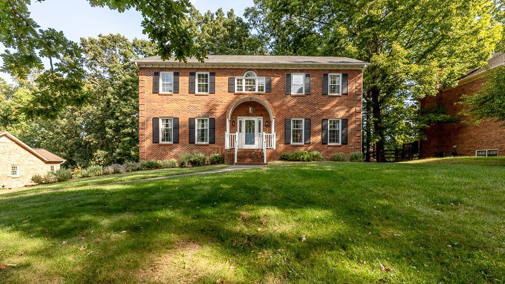 Exterior Front Photo of house. Two Story Brick with Black Shutters and Semi-circle covered front stoop