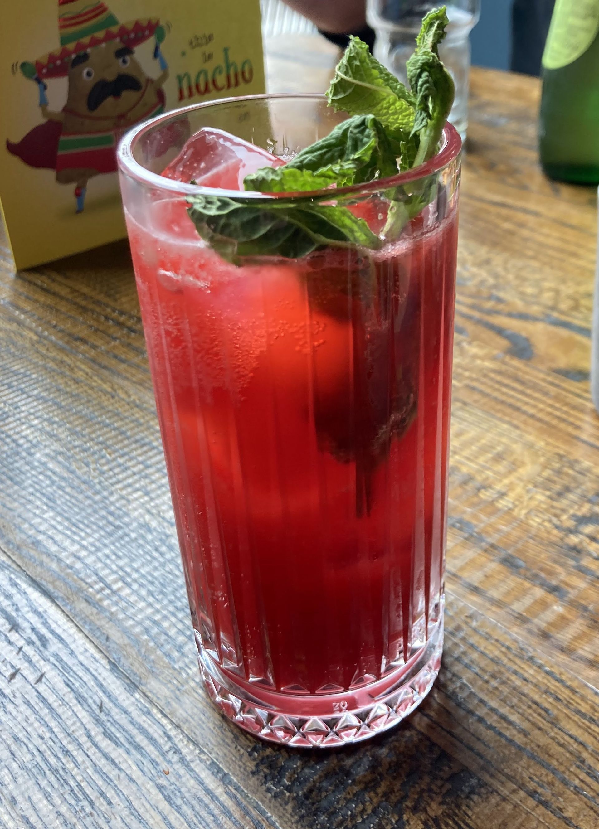 Mocktail red drink in tall glass with mint on the top