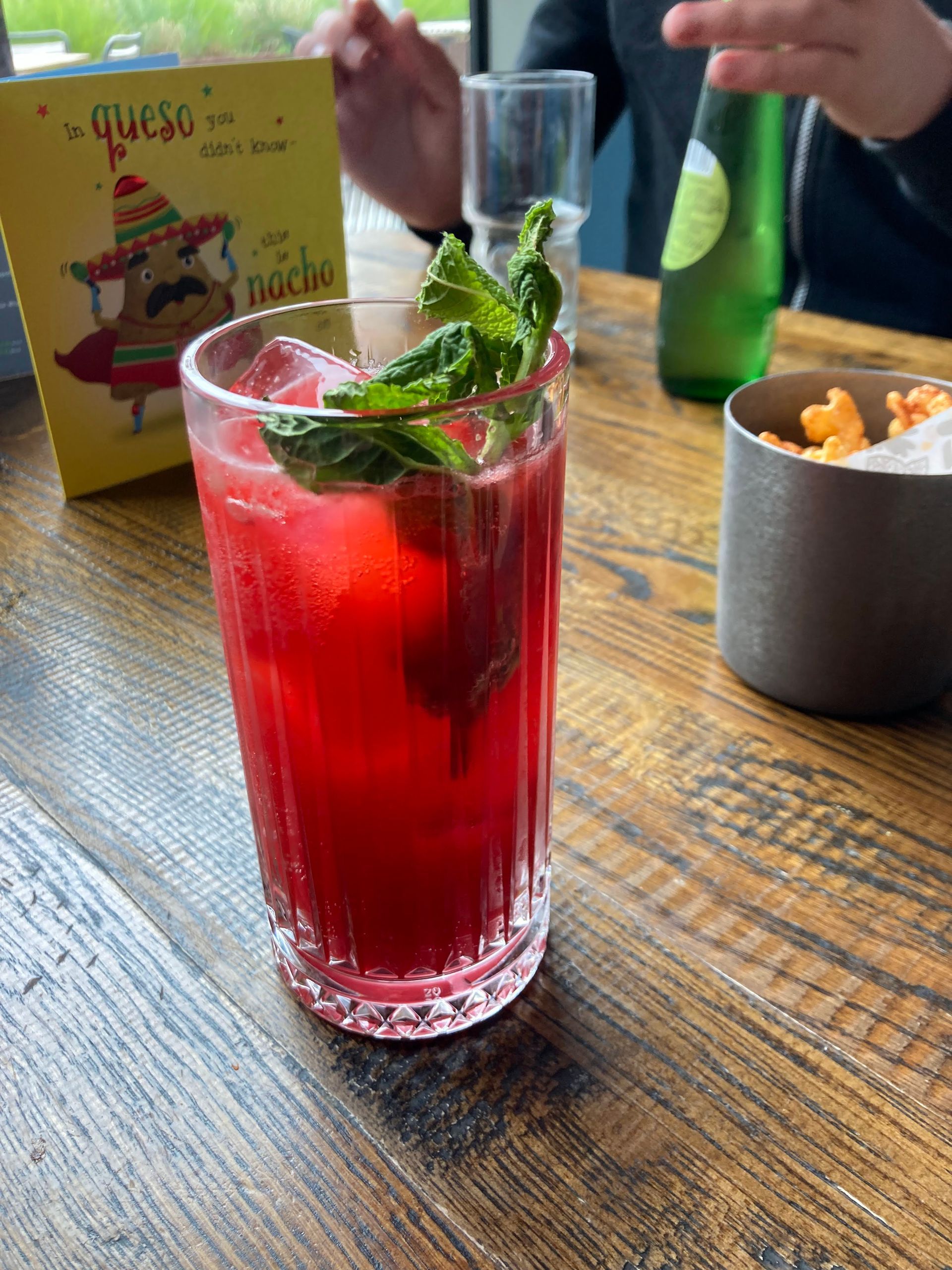 Mocktail red drink in tall glass with mint on the top