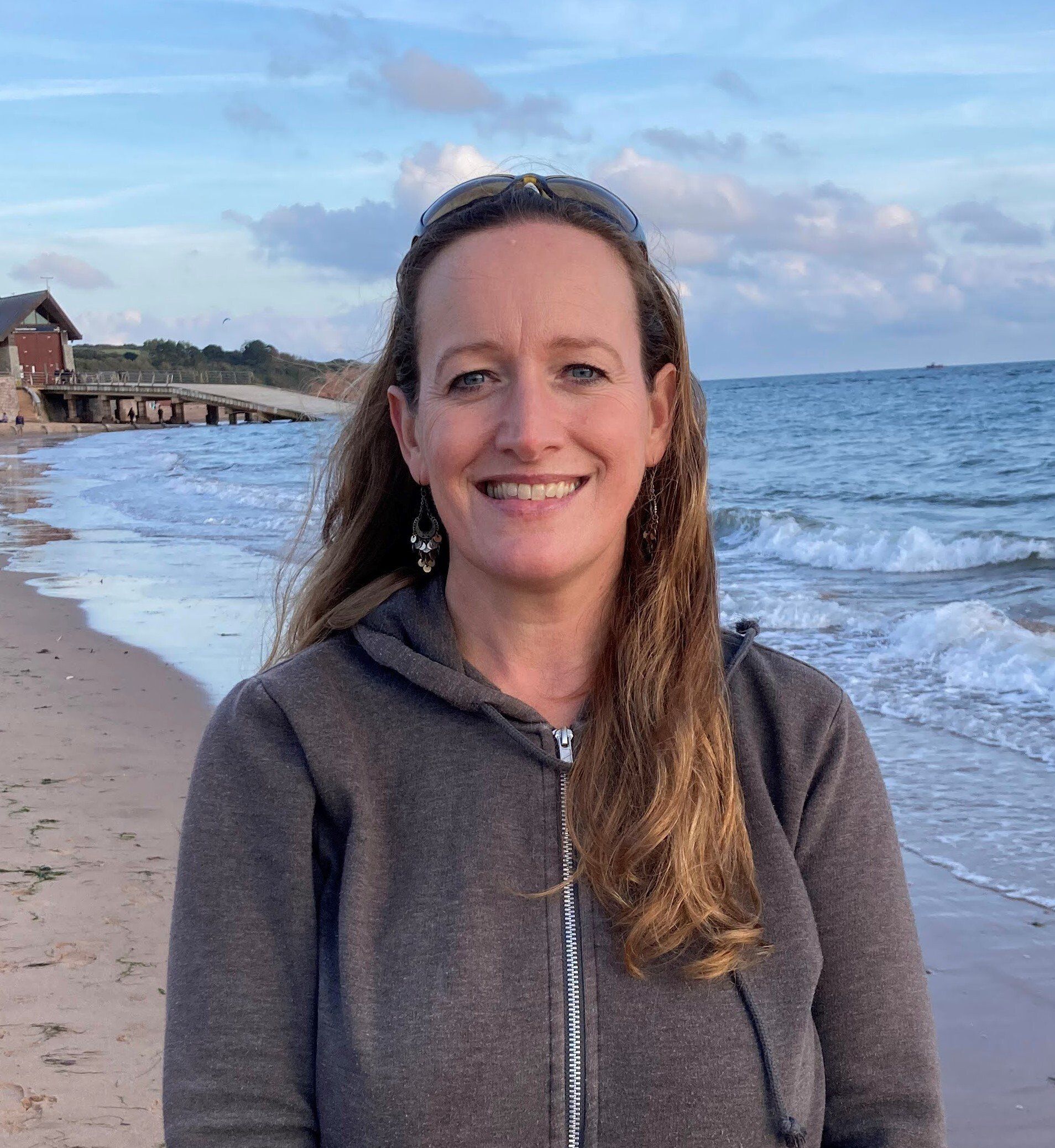 Anna Pittard head and shoulders standing on a beach