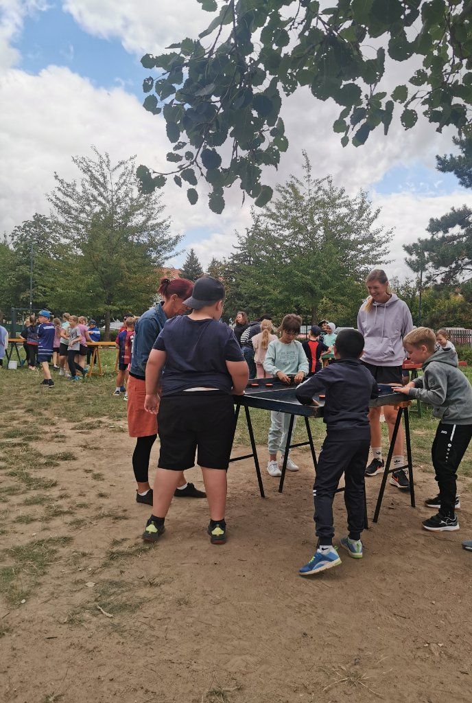 Mehrere Kinder stehen um einen Tisch und spielen gemeinsam
