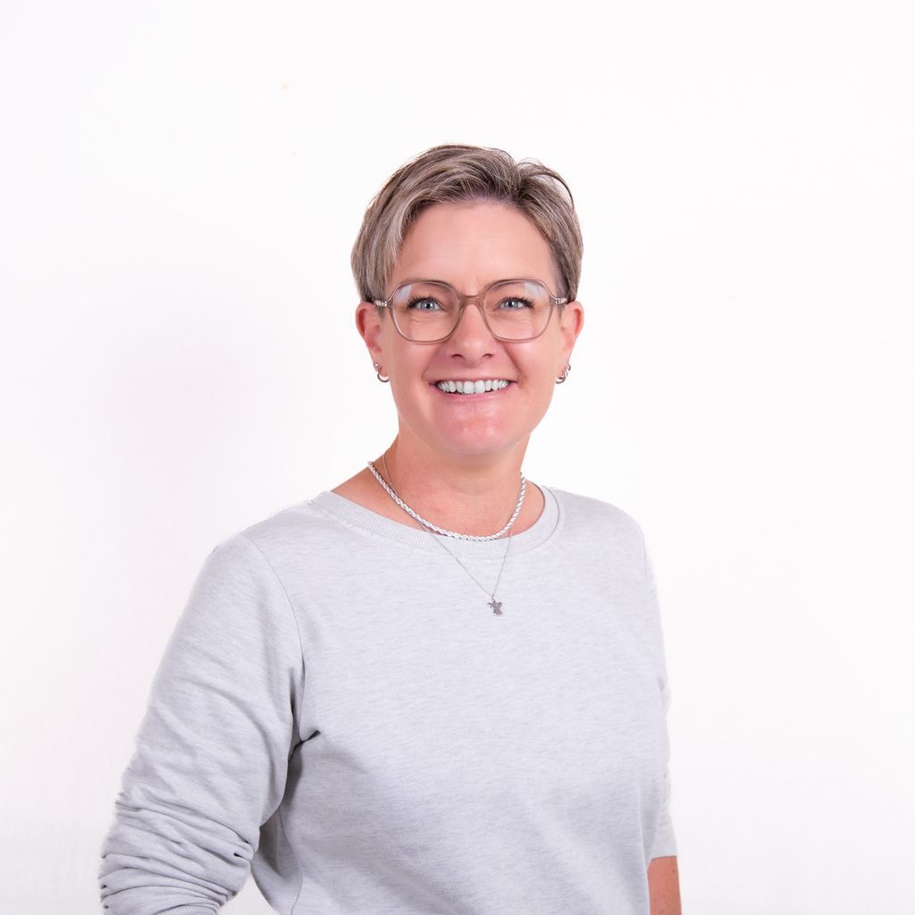 Friseurmeisterin Münster Friseur Haarexpert blonde kurze Haare, undercut Brille , Kette, lächeln,